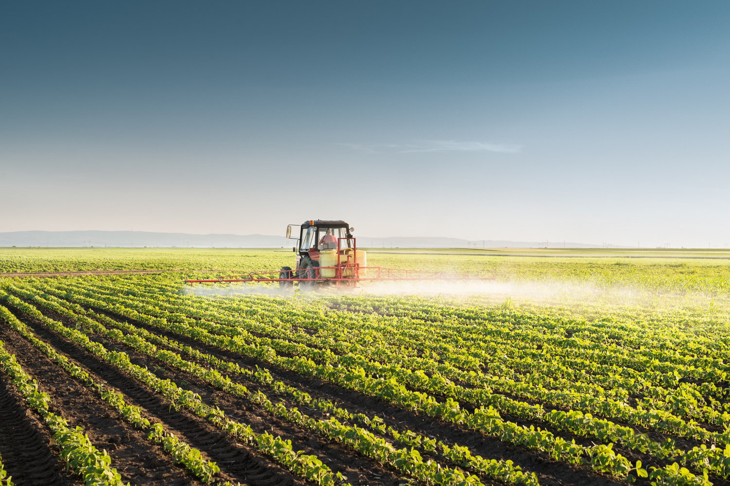 Tractor spraying soybean